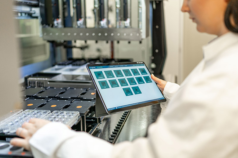 Wissenschaftlerin arbeitet mit einer Steuerungssoftware an einer automatisierten Laboranlage