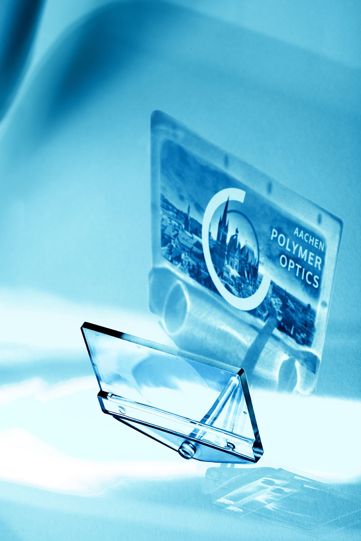 Key Visual der Aachen Polymer Optics Days 2023: Kunststoffoptik mit Motiv des Aachener Doms