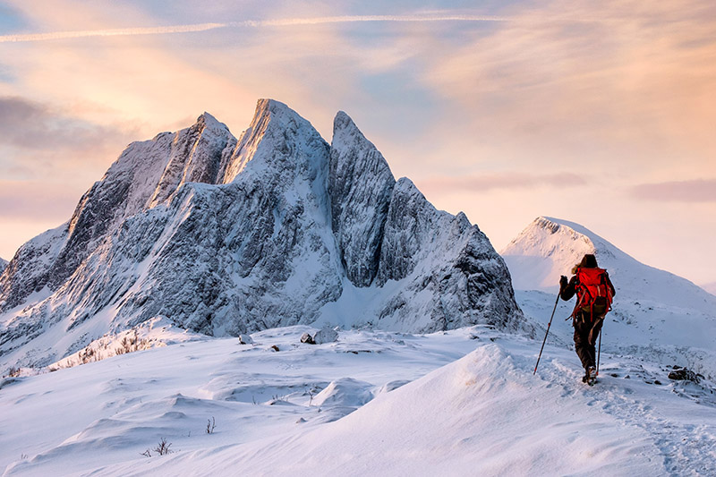 Mountaineer man climbs on top snowy mountain