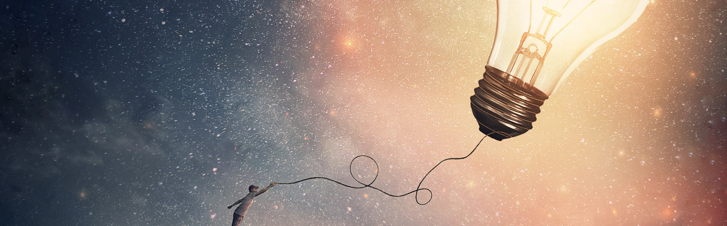 Creative idea concept with a person on the edge of a cliff holding the string of a lightbulb kite or a bulb balloon. Surreal adventure, conceptual scene, genius thinking